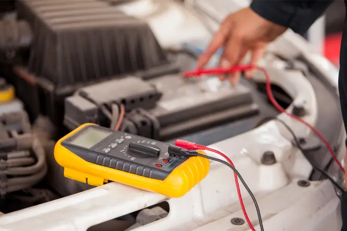 Multimeter being used to test a car battery